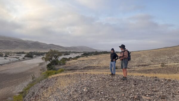 Two Hikers on the escarpment of the Hoarusib River watching elephants in Namibia